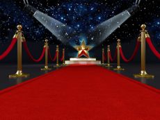 Red carpet with a star shape on the platform lit by two spotlights.