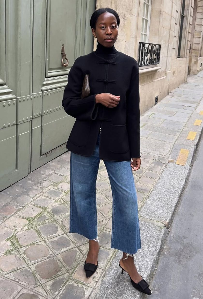 @sylviemus_ wears a black jacket, high-neck top, cropped flare jeans and mules