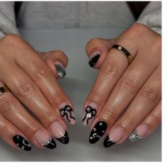 a person wearing a black manicure with mixed designs