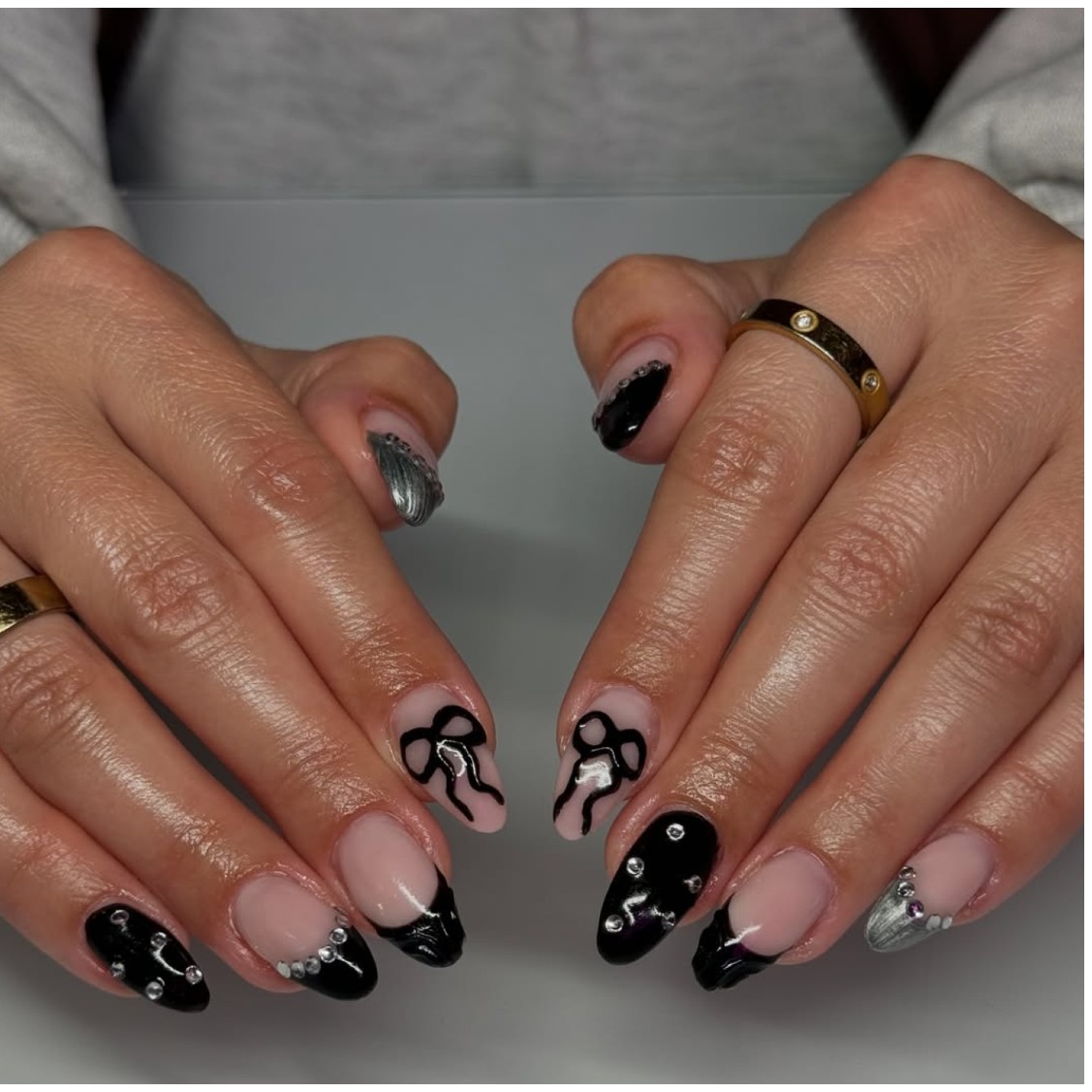 a person wearing a black manicure with mixed designs