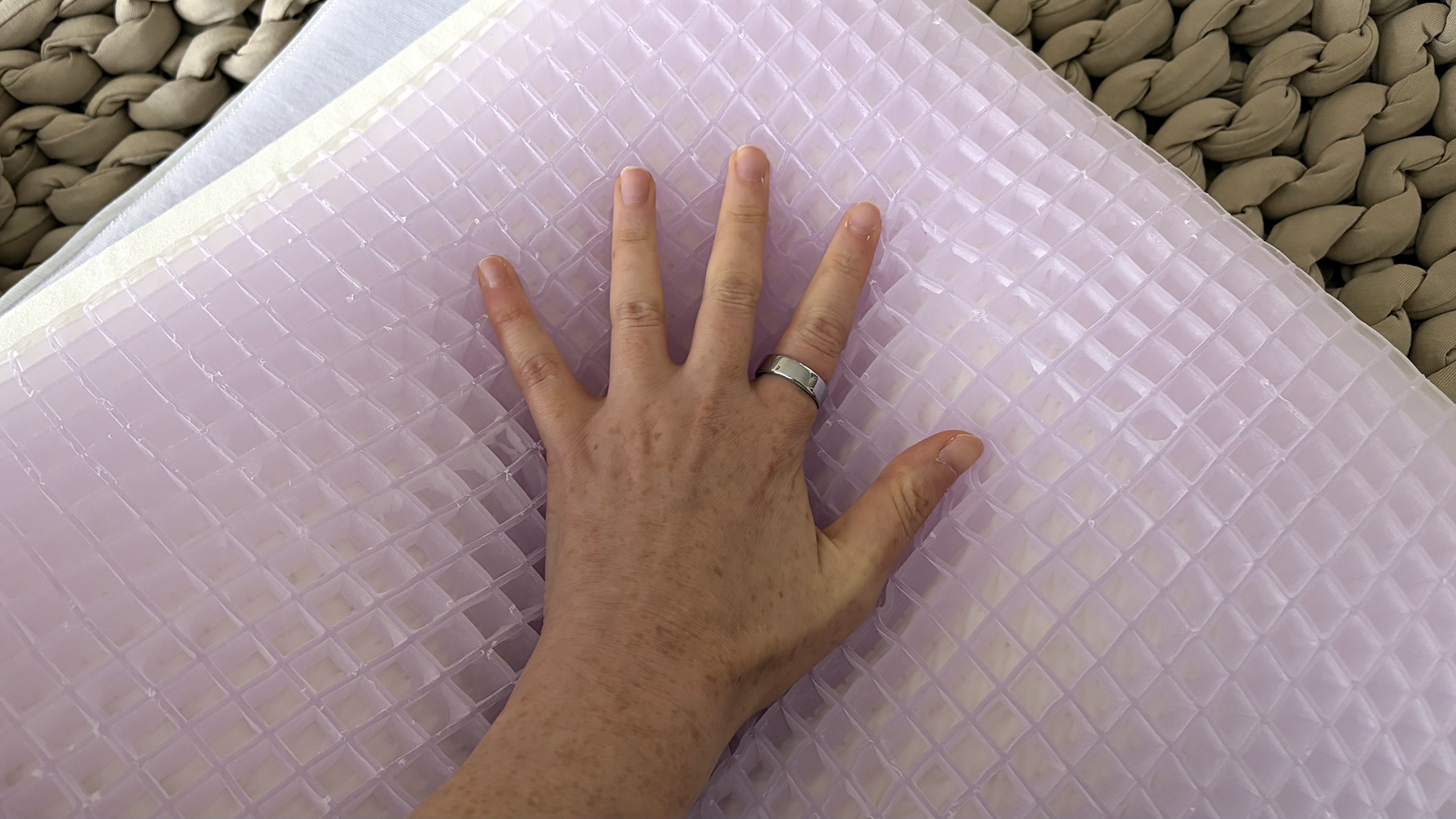 A close up of a hand pressing into the GelFlex Grid inside the Purple DreamLayer pillow
