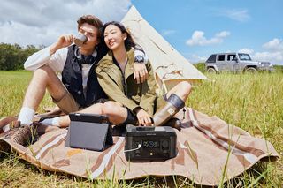 Young male and female seated outdoors, with the EcoFlow RIVER mini Portable Power Station on the right side of the screen.