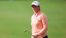 Lottie Woad walks off the green with a putter in hand