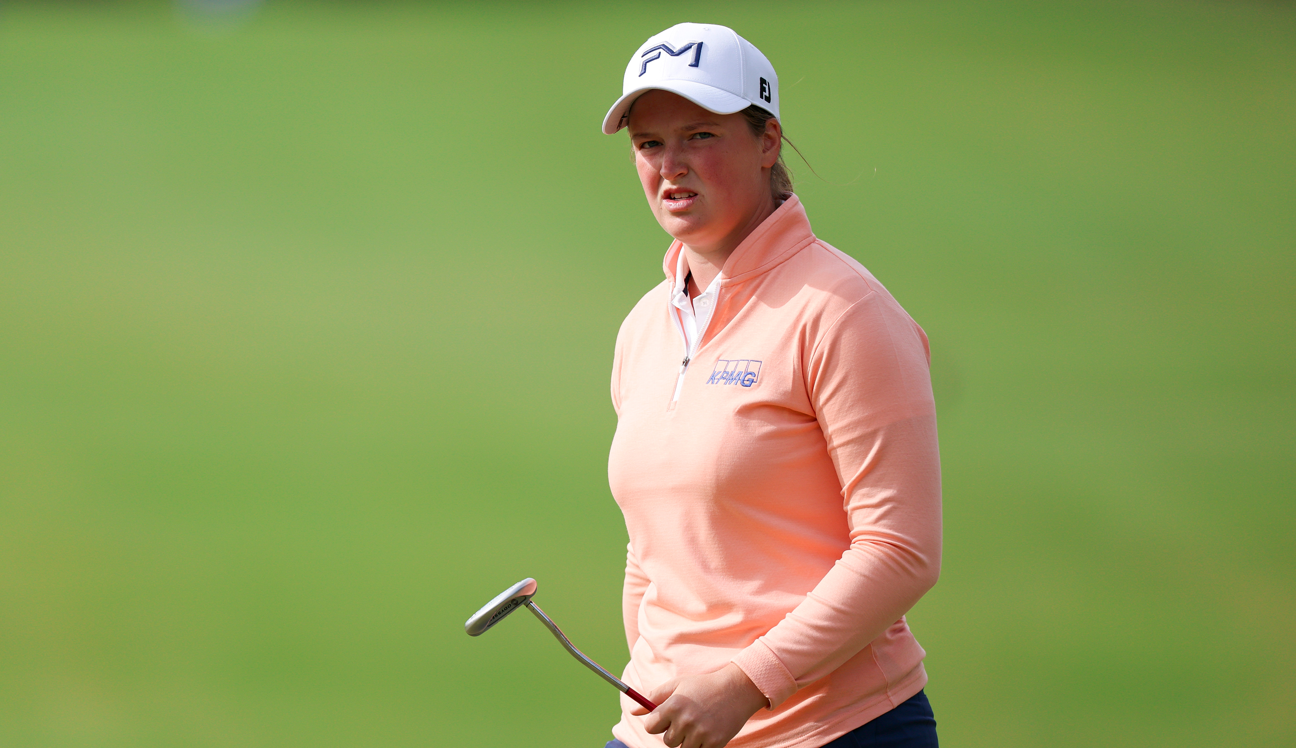 Lottie Woad walks off the green with a putter in hand