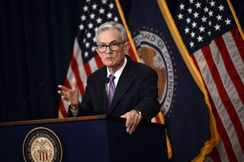 US Federal Reserve Chair Jerome Powell speaking at podium with american flags and fed seal in the background