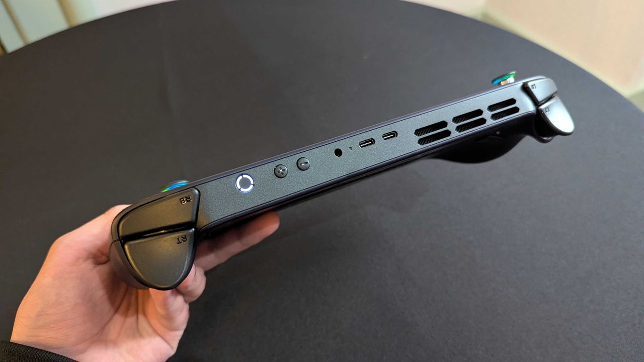 A Lenovo Legion Go S with SteamOS held in the hand and seen from the top, showing its buttons, 3.5mm audio jack, dual USB Type-C 4.0 ports, and top ventilation.