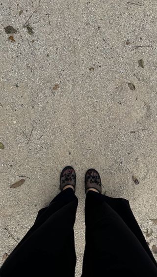 A photo of Kendall Jenner wearing black mesh flats and matching pants on the beach.