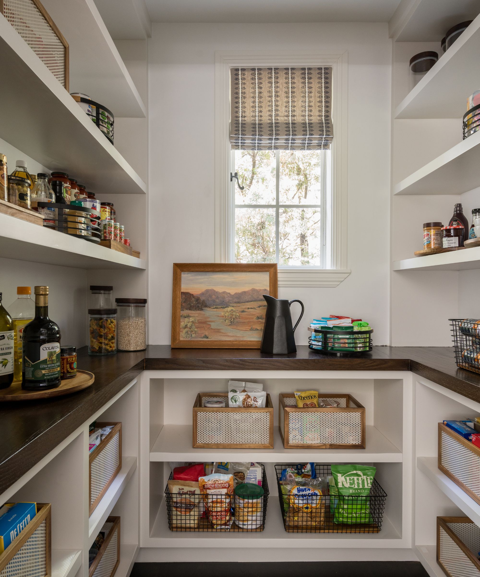 A walk in pantry with wraparound shelving and a small window