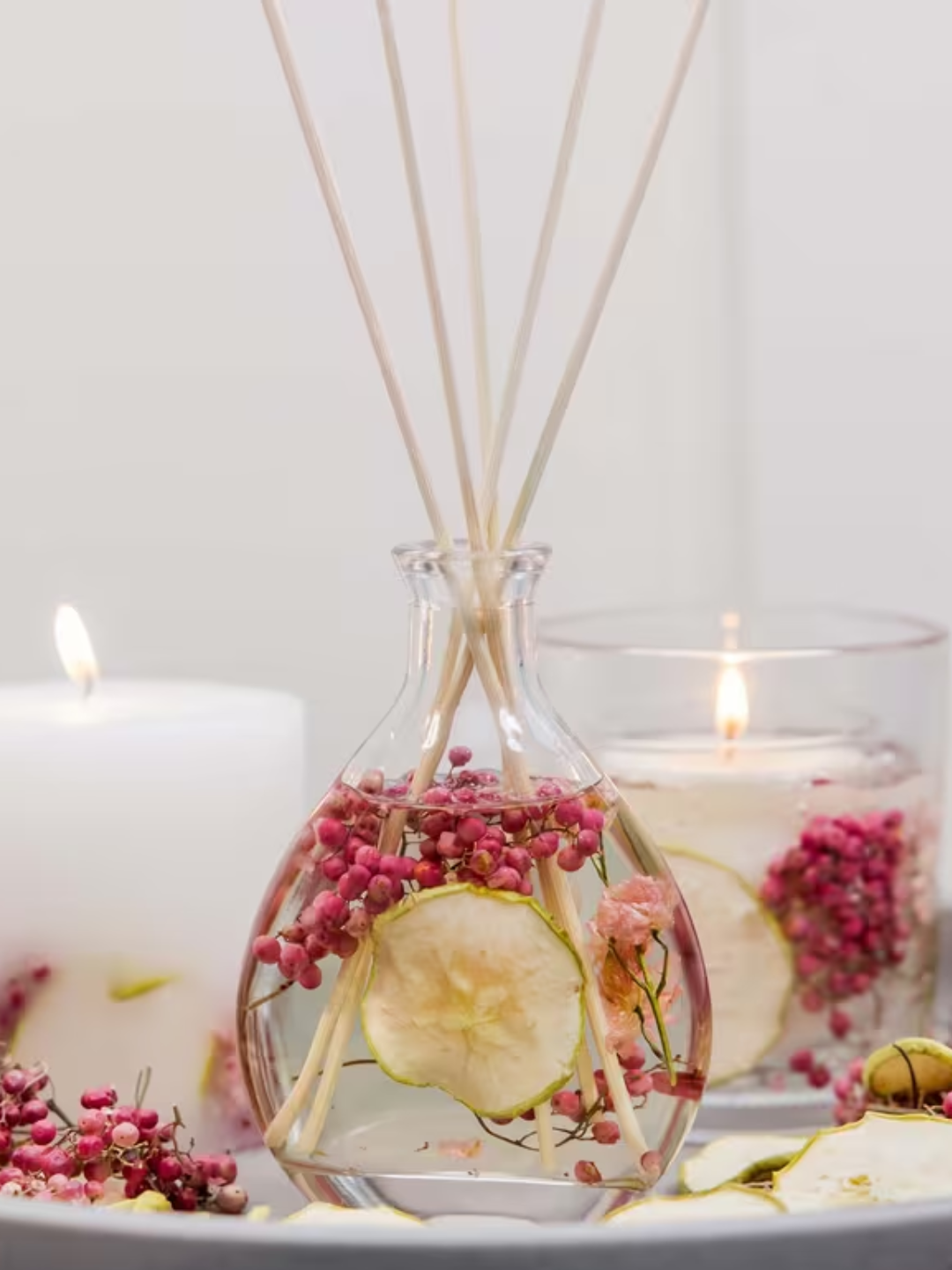 A glass diffuser with dried pear and berries