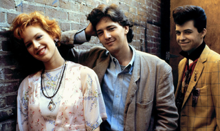 Molly Ringwald, Andrew McCarthy, and Jon Cryer pose next to a wall in 'Pretty in Pink.'