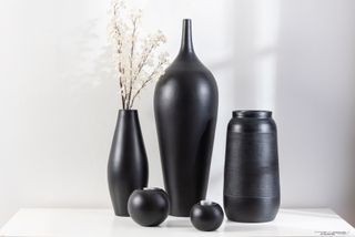 Three modern black ceramic vases, with a unique floral arrangement