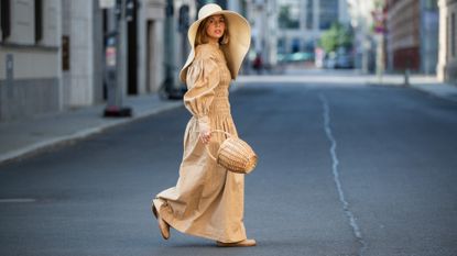 Amelie Stanescu is seen wearing beige Ganni dress, floppy hat COS, Maison Margiela tabi shoes, Mango basket bag on June 29, 2021 in Berlin, Germany.
