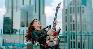 Bella Perron plays an Ibanez guitar