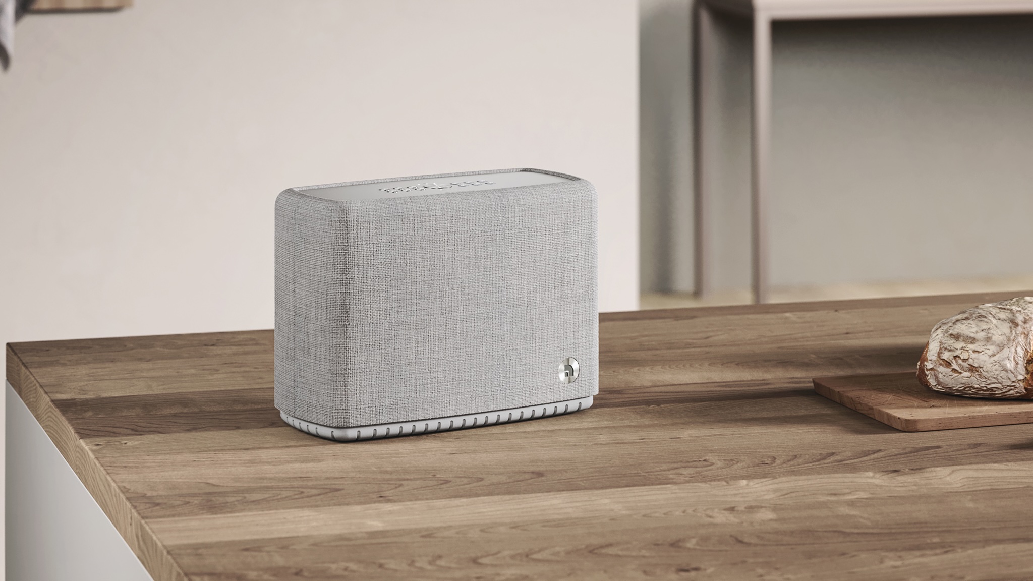 An Audio Pro A15 W speaker on top of a wooden kitchen countertop or island