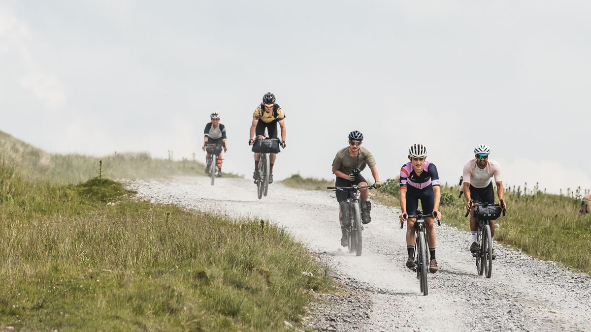 A group of riders descending together on a gravel road