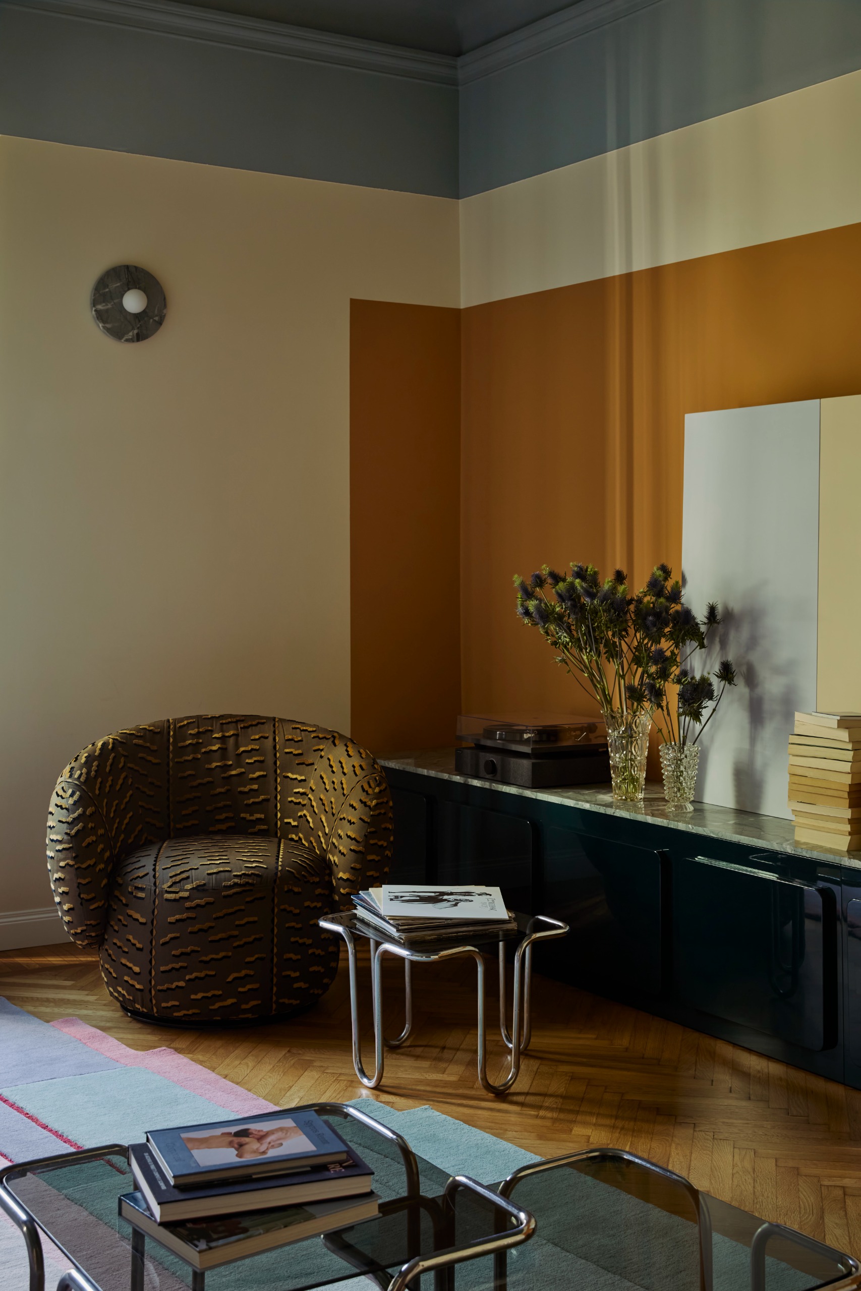 living room with geometric color blocking paint on the walls, modernist furniture and a printed arm chair