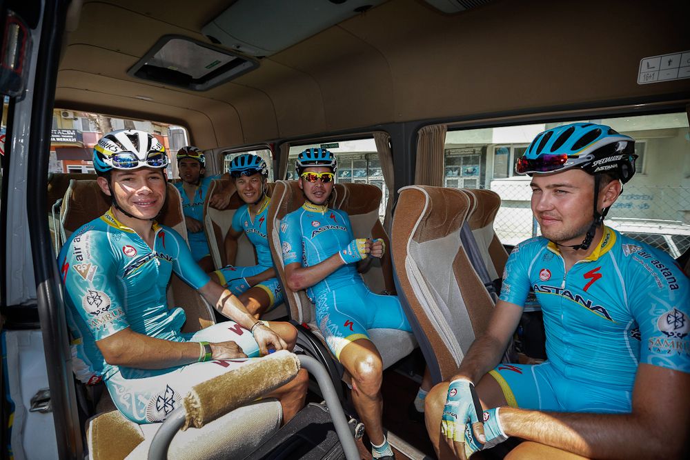 The Astana team wait in the team vehicle.