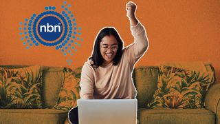 Woman sitting on sofa with a laptop in front of her on a table. She is punching the air in happiness and she is smiling. The NBN Co logo is to her left and the background is orange.