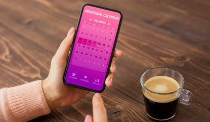 Female using menstrual calendar app on mobile phone, period tracker apps