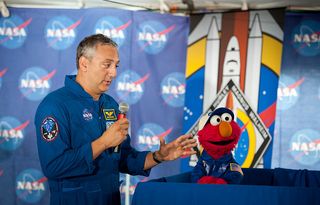 NASA astronaut Mike Massimino, left, and Sesame Street's Elmo speak at the STS-135 Tweetup on July 7, 2011 at Kennedy Space Center in Cape Canaveral, Fla. Elmo asked the astronauts questions about living and working in space.