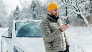 man using phone in winter