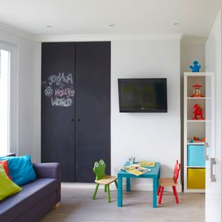 kids room with white wall and slate board wardrobe with tv on wall