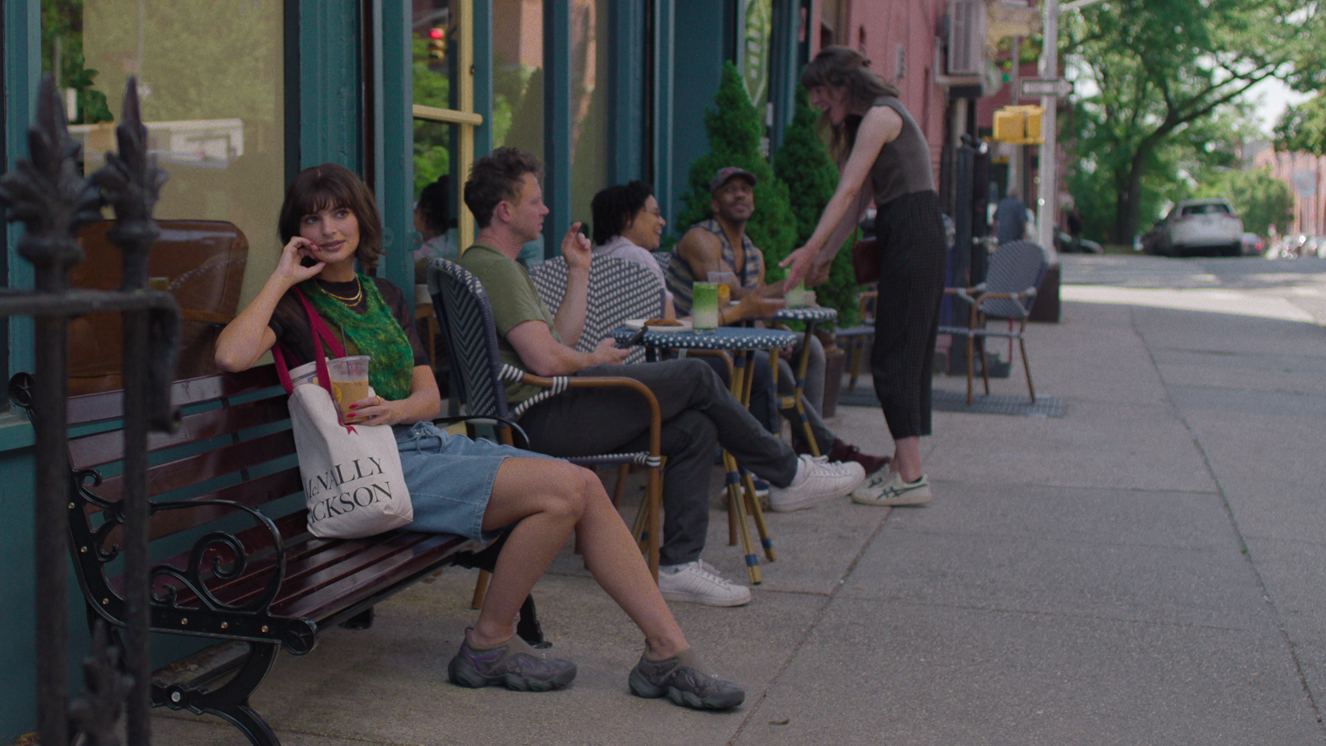 emily ratajakowski as emily sitting on a bench outside of a brooklyn cafe in too much