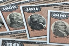 U.S. series EE savings bonds in different denominations layered over each other.