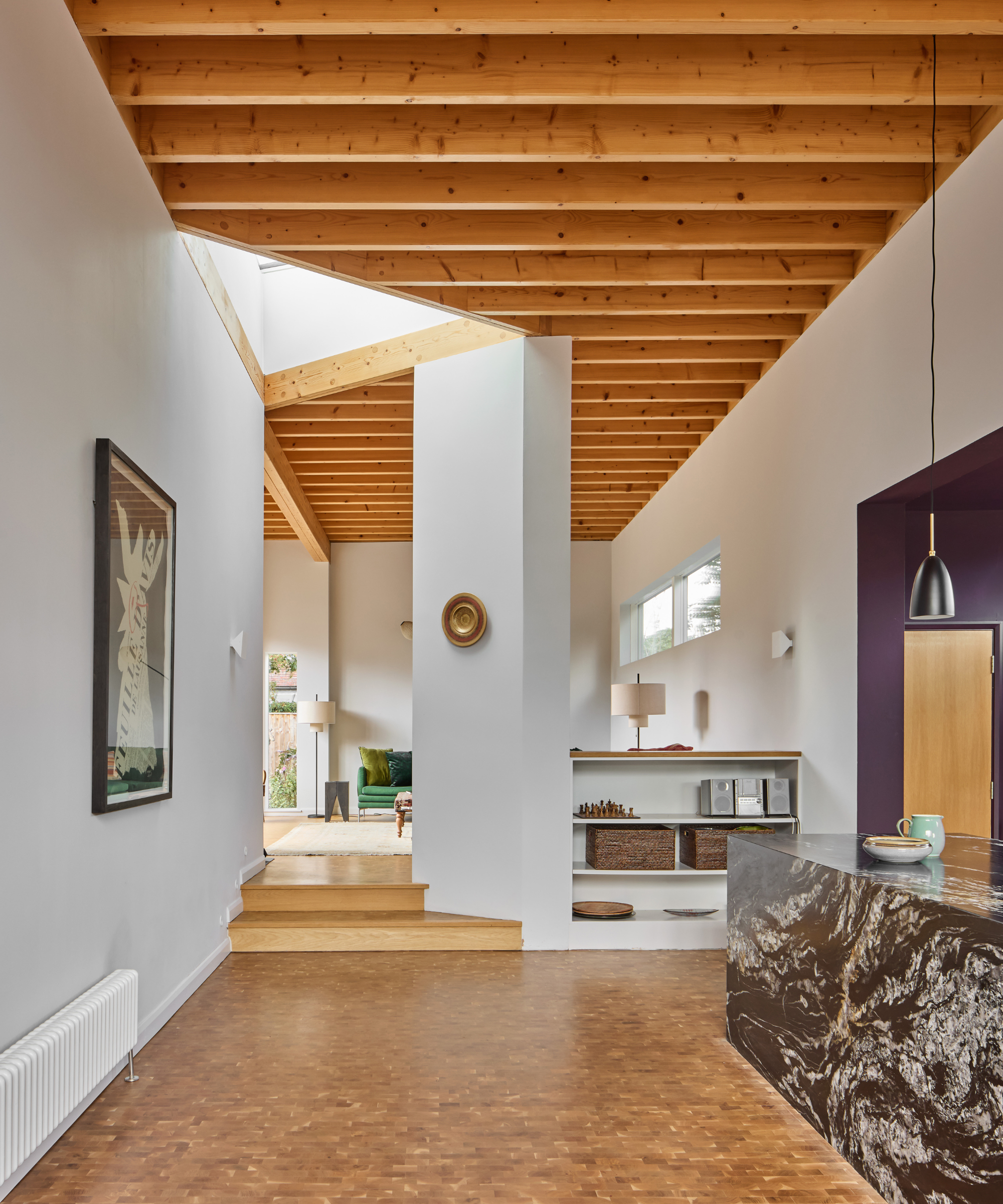Kitchen with beam ceiling and rooflight leading into another room up a level