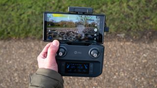 Holy Stone HS600D drone controller held in a hand outside