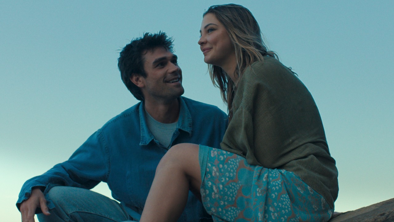 KJ Apa looking up at Madelyn Cline, who is looking out to the distance.