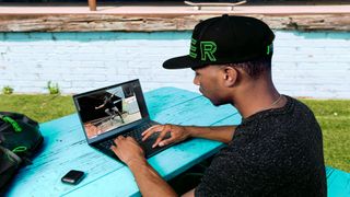 a man sitting with a black laptop