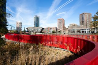 Asif Khan boardwalk at Canada Water bright red bridge across water and natural water wildlife habitat