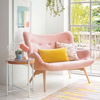 Seating nook with pink armchair and hanging plant