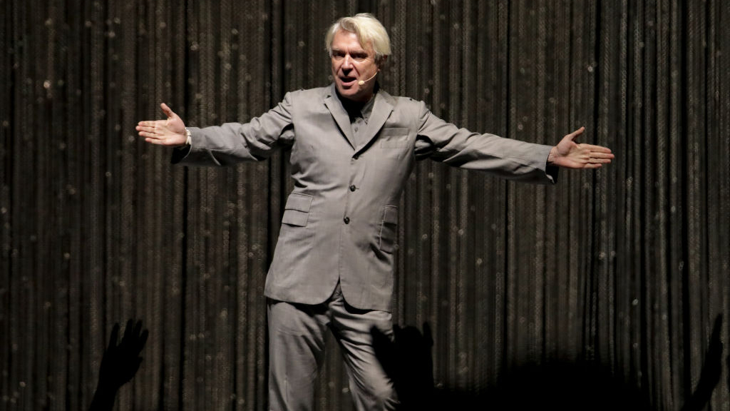 David Byrne, extending his arms