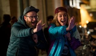 Seth Rogen and Charlize Theron waving in Long Shot