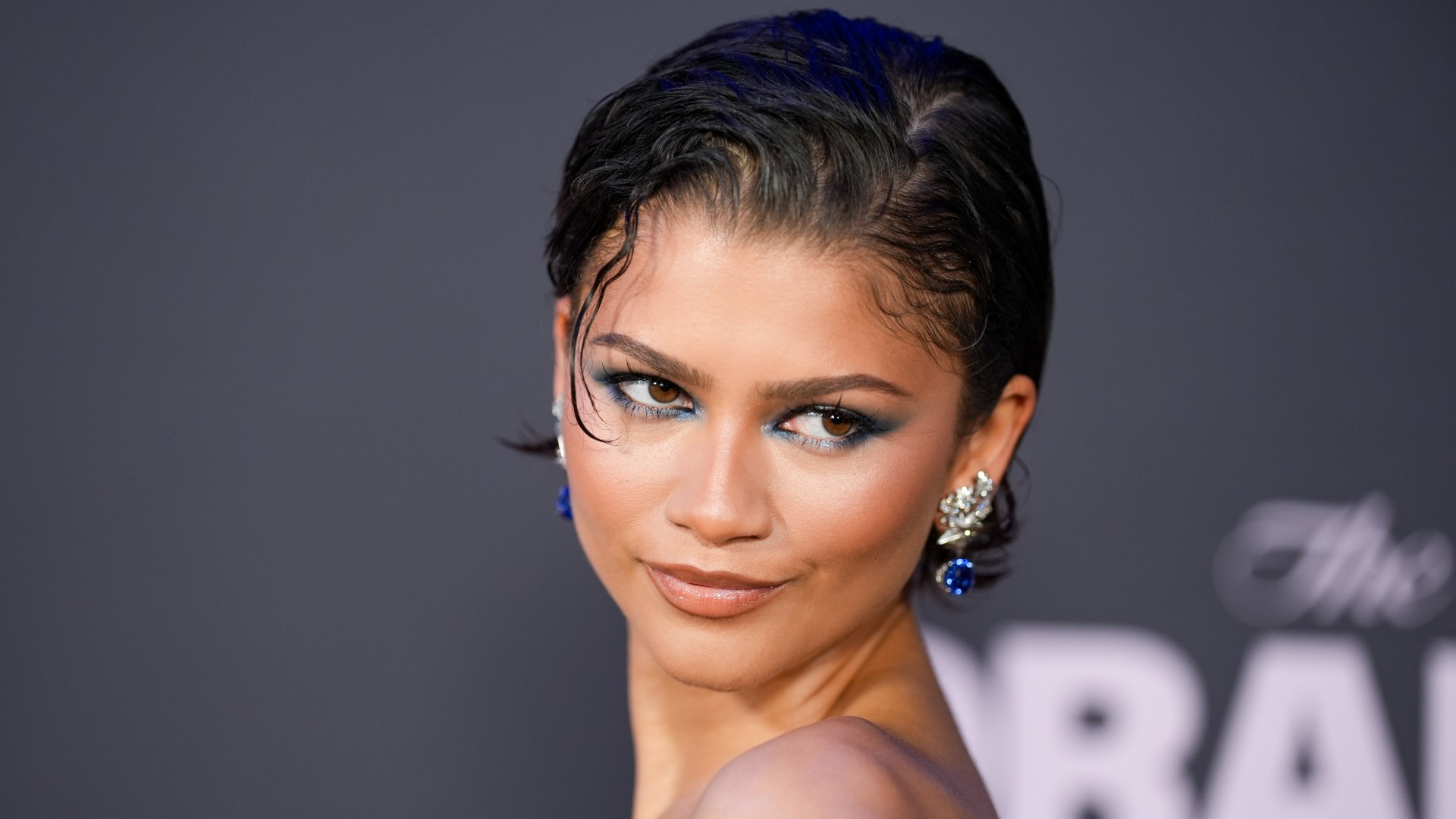 a young woman wearing blue eye makeup