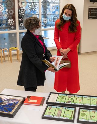 Catherine, Duchess of Cambridge is shown the artwork on display by Director of Vital Arts for Barts Health NHS Trust, Catsou Roberts, during a visit to the Royal London Hospital Whitechapel on May 7, 2021 in London, England