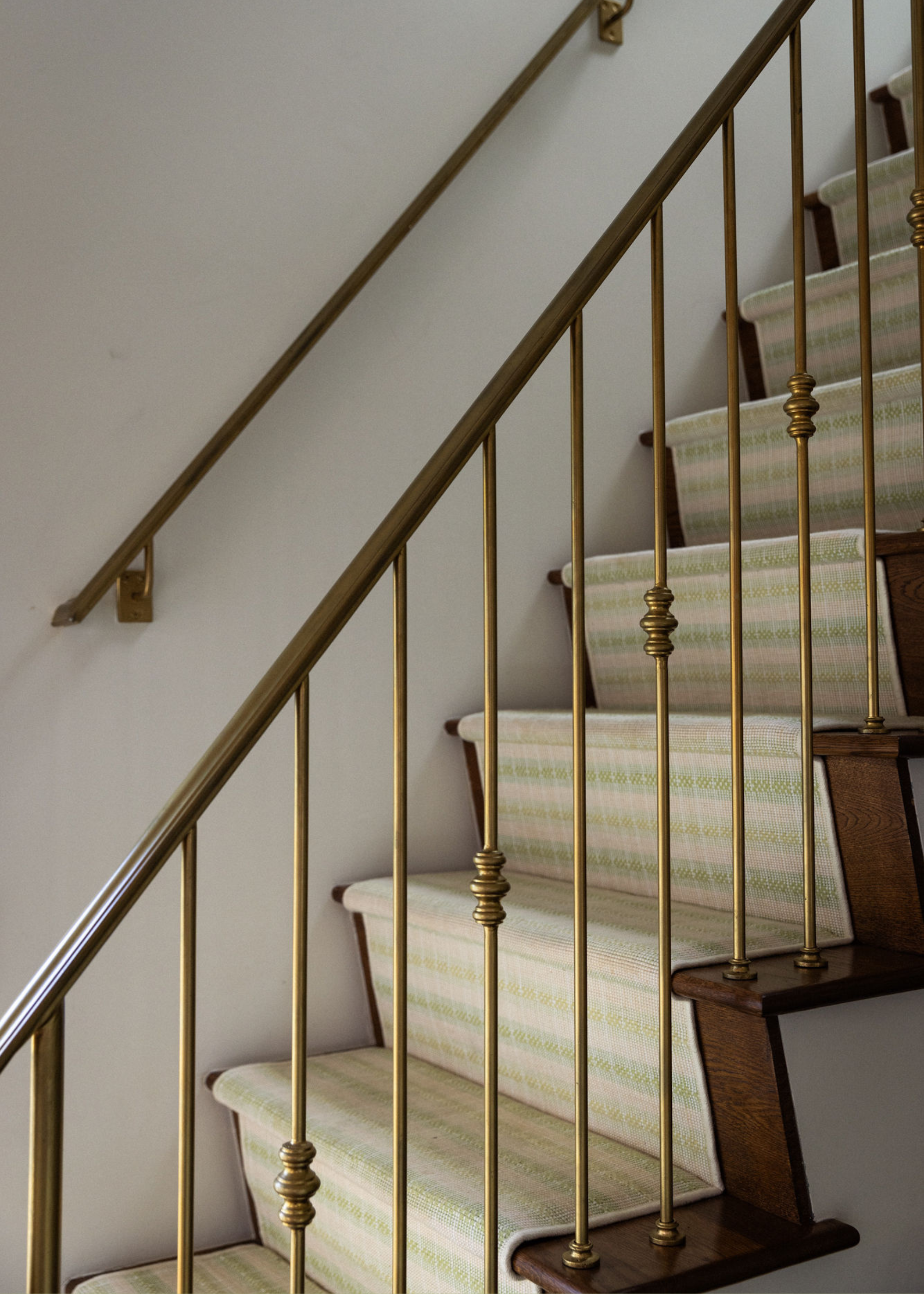 A wooden staircase with a stripey fabric tread