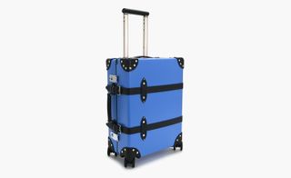 Centenary Carry On luggage, by Globe-Trotter. A blue hard shell case on wheels with a black handle.