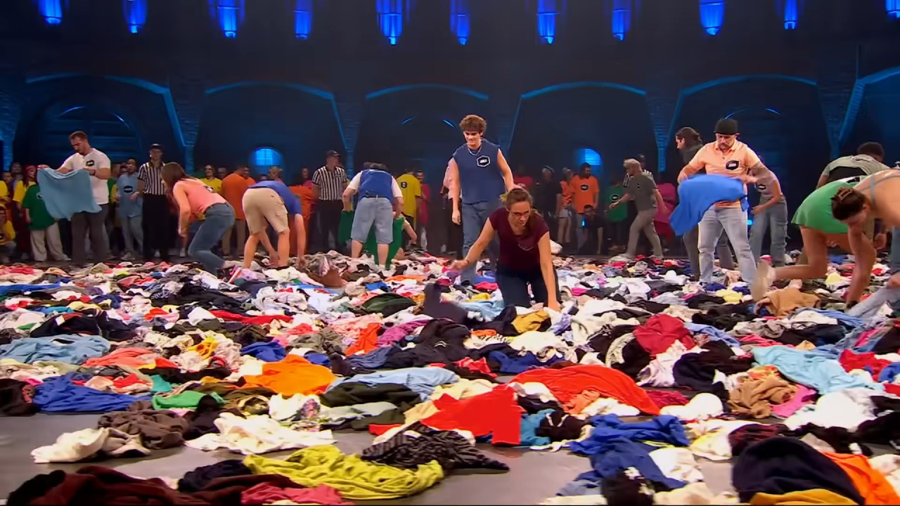 99 to Beat contestants search through shirts.