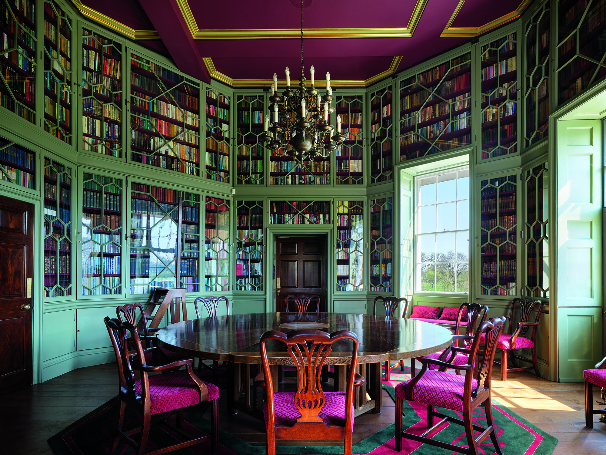 a magnificent room complete with floor to ceiling bookshelves and a grand central table