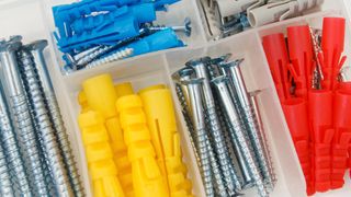 plastic container with screws and different colour rawlplugs
