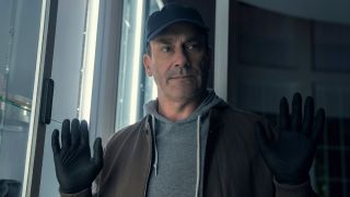 Jon Hamm holding his hands up while wearing gloves in Your Friends & Neighbors. 