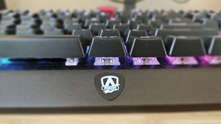 An AOC AGON AGK700 keyboard on a wooden desk