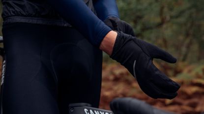 Male cyclist pulling on a pair of winter cycling gloves