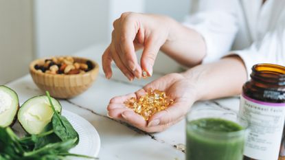 woman with omega-3 capsules in her palm