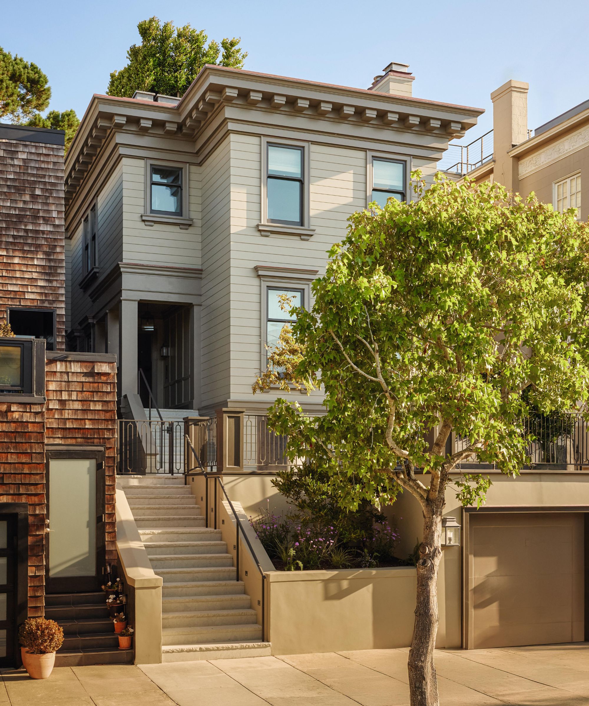 a large restored 1905 home in San Francisco with elevated front steps and a grey paneled facade