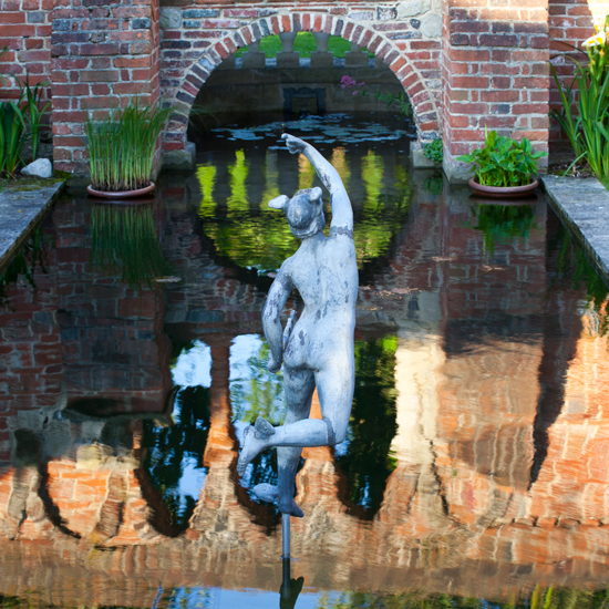 statue with plant and pond