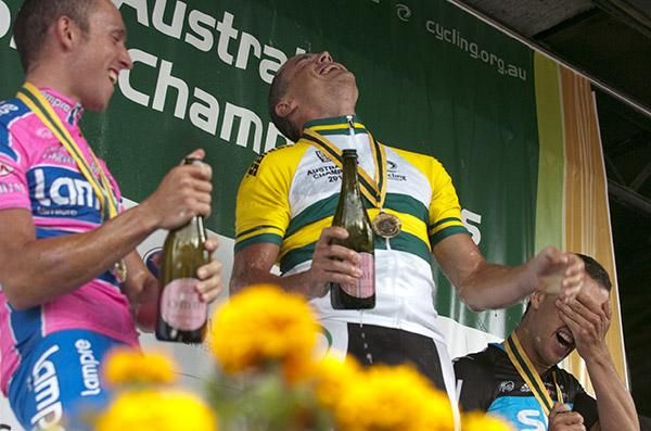 Oh yeah, you little beauty! Simon Gerrans enjoys the spoils of a gold medal on the podium with Matt Lloyd (left) and Richie Porte.